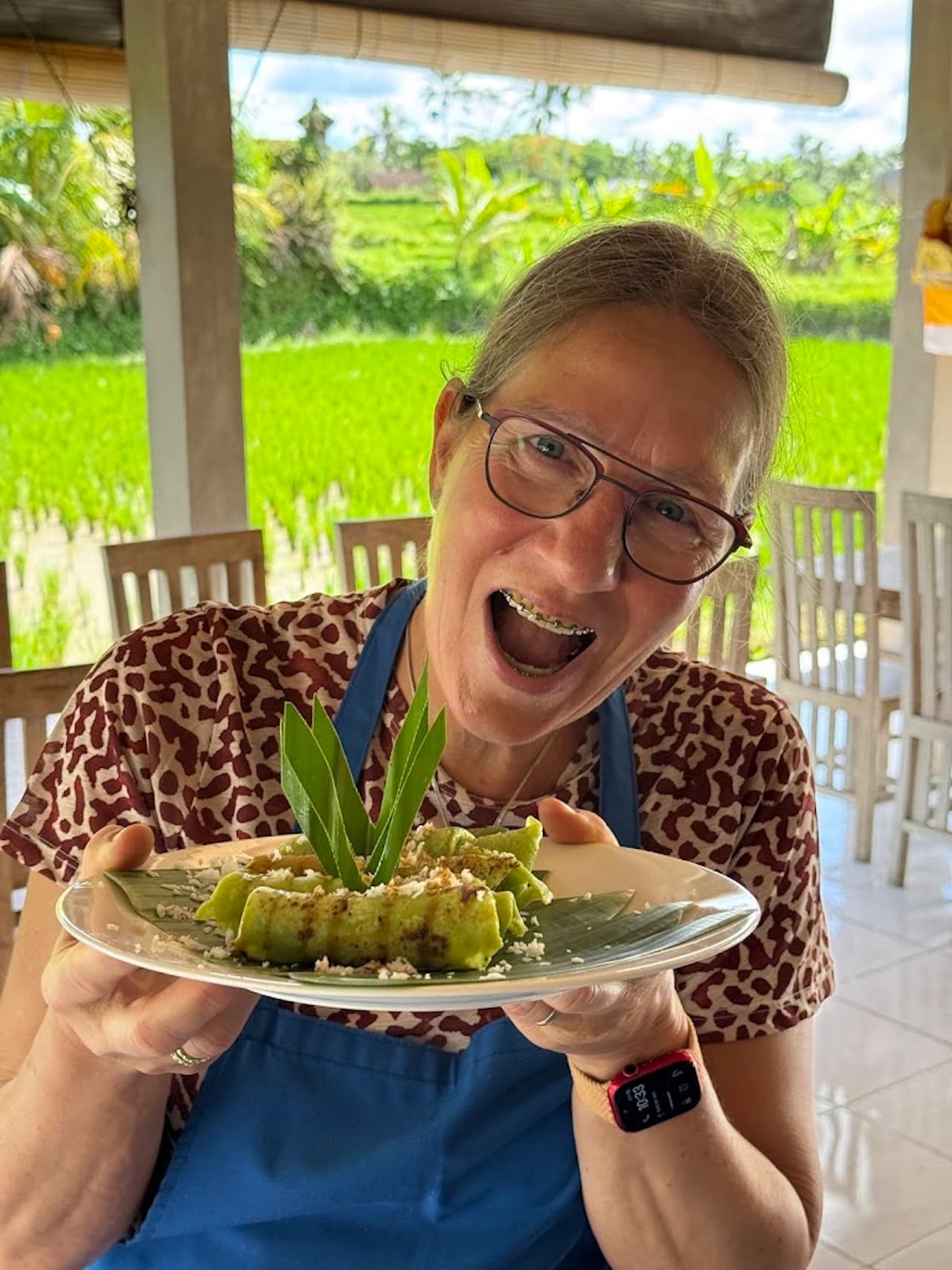 A guest holding a plate of green coconut crepes